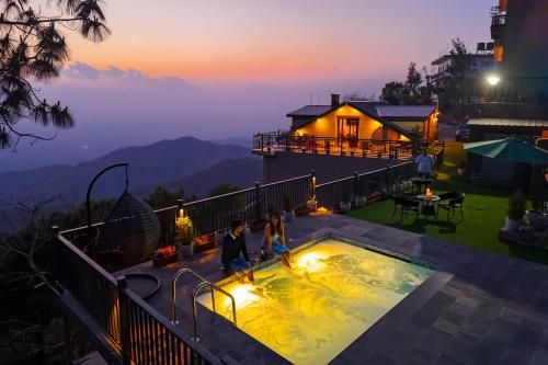 a couple standing in a hot tub on top of a house at Konifer Greyvine in Kasauli