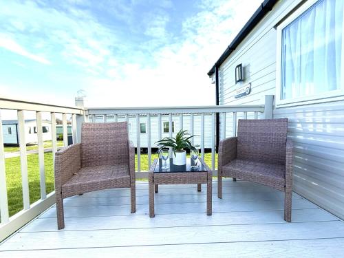 two chairs and a table on a balcony at Dunlin Retreat in Flamborough