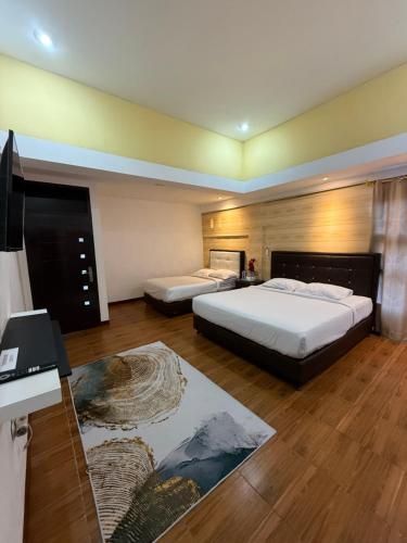 a bedroom with two beds and a desk with a computer at Villa Copenhagen Bukittinggi in Bukittinggi