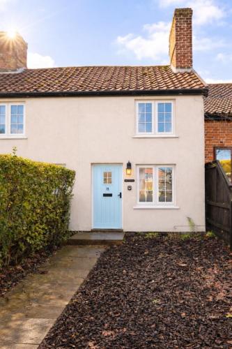 a white house with a blue door at Daisy Cottage - Framlingham in Framlingham
