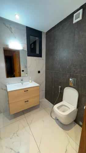 a bathroom with a toilet and a sink and a mirror at CfC in Casablanca
