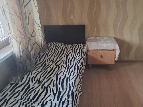 a zebra print bed in a room with a window at Hotel kazbegi1 in Kazbegi