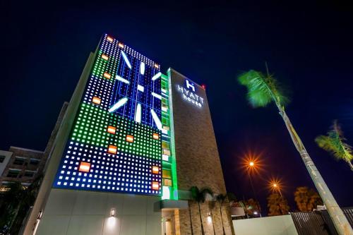 a tall building with blue and green lights on it at Hyatt House San Juan in San Juan