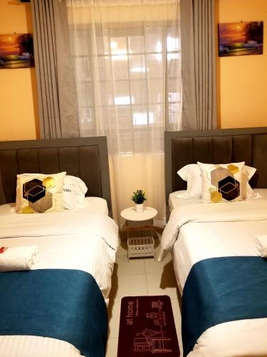 a bedroom with two beds and a window at Embu Air-bnb 1&2 Bedroom homestay-O79546IO36 in Embu