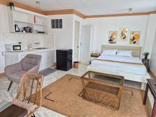 a bedroom with a bed and a chair and a table at RM Apartments in Idanao