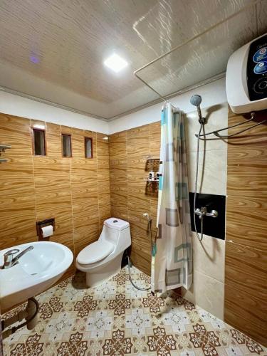 a bathroom with a white toilet and a sink at Villa Copenhagen Bukittinggi in Bukittinggi