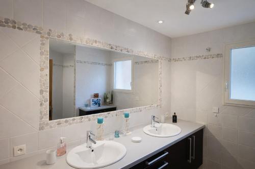 a bathroom with two sinks and a large mirror at Bastide des Civayeres in Veynes