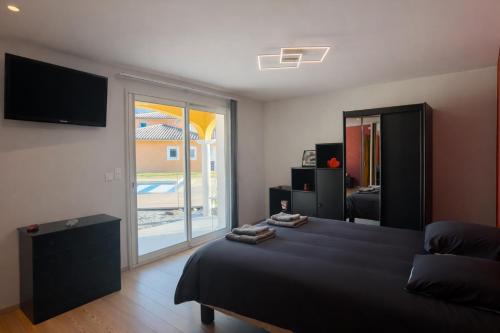 a bedroom with a bed and a sliding glass door at Bastide des Civayeres in Veynes