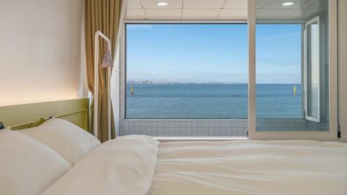 a bedroom with a bed with a view of the ocean at Pohang Etoile Poolvilla in Pohang