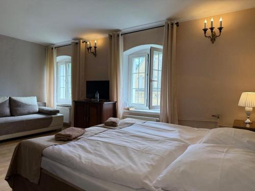 a bedroom with a large white bed and a couch at Pałac Henryków in Szprotawa