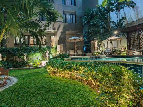 a resort with a yard with a swimming pool at Silom Serene A Boutique Hotel in Bangkok