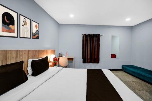 a bedroom with a large bed and a green couch at Super Townhouse Richmond MG Road Metro Formerly Richmond Residency in Bangalore