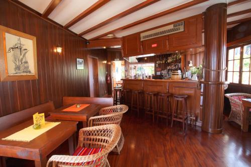 een restaurant met een bar en tafels en stoelen bij Vila Ventura in Caniço