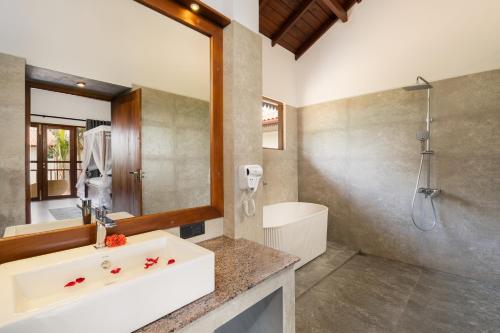 a bathroom with a sink and a shower and a mirror at Arinna Beach Resort in Tangalle