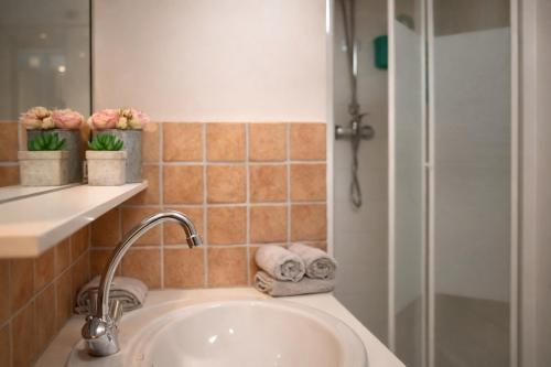 un bagno con lavandino e doccia con asciugamani di Les Terrasses a Barneville-Carteret