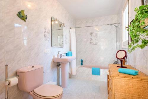 a bathroom with a toilet and a sink and a shower at Villa Pearla by Villa Plus in Cala en Porter