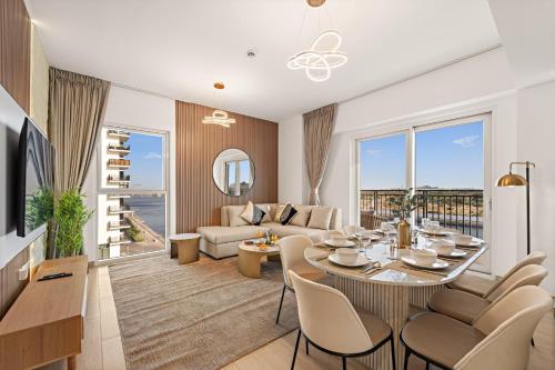 a living room with a table and chairs and a couch at Desert Key - Perfectly Located Yas Island Apartments in Abu Dhabi