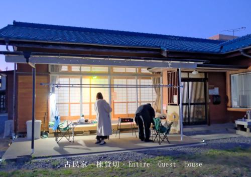 two people standing on a patio of a house at 古民家宿Tabi湊 in Hitachinaka