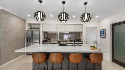 a kitchen with a large white island with bar stools at The Cabana Oasis in Woorim