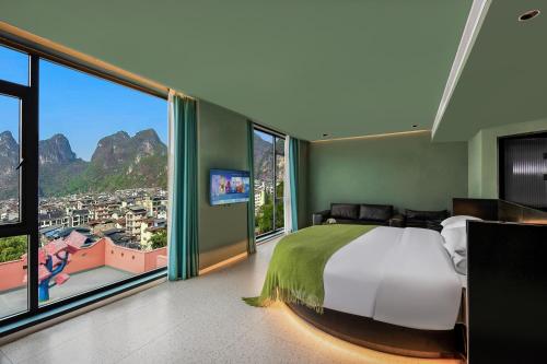 a bedroom with a large bed and large windows at Yangshuo B&G Hotel-Exclusive location,Roof Top Viewing Terrace,Seasonal swimming pool,Free Self-Service Laundry & Drying, Entrance Ticket Serivce, Local Trip plan,E-Scooter& English Customer Service in Yangshuo