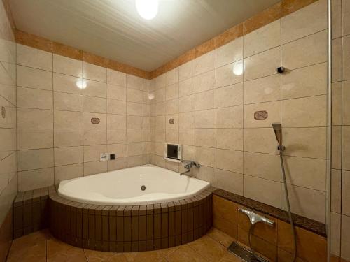 a bathroom with a large tub and a shower at ホテルカホウ 千葉土気店 Chiba-Toke "蘇我ICから車で20分 茂原市街から車で15分" in Chiba