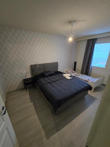 a small bedroom with a bed and a window at Mudita Apartment in Mikkeli