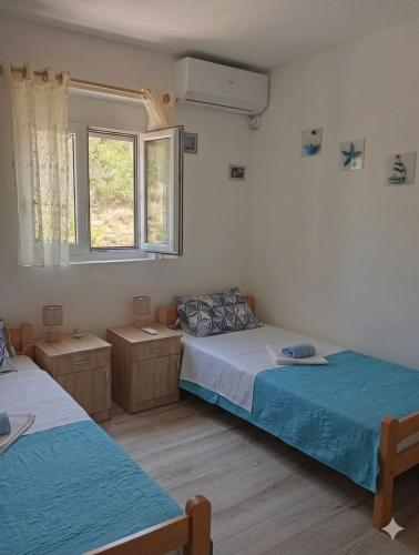 a bedroom with two beds and a window at Vila Rogač in Tivat