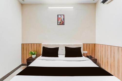 a bedroom with a large white bed with black pillows at Collection O Rispana Pul Dehradun Formerly Hotel Square 1 in Clement Town