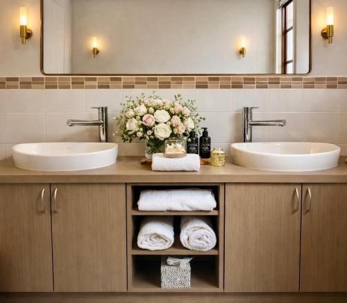 a bathroom with two sinks and a vase of flowers at Balingup Highview Chalets in Balingup