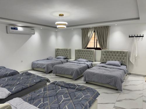 a room with four beds and a couch at استرحه ام الحمام in Suḩaybah
