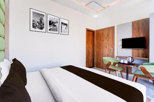 a bedroom with a bed and a desk and a tv at Townhouse Govardhan in Govardhan