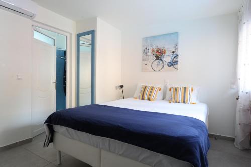 a bedroom with a bed with a blue blanket at The Bordeaux Door in Egina