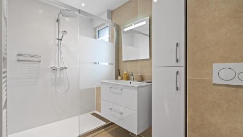 a white bathroom with a shower and a sink at Bel Apt neuf - HyperCentre 400m Plage-Pkg-Wifi-T3 in Arcachon