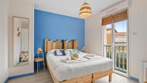a blue bedroom with a bed with a wooden headboard at Bel Apt neuf - HyperCentre 400m Plage-Pkg-Wifi-T3 in Arcachon