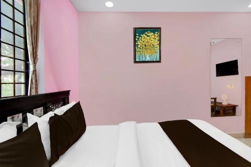a bedroom with a bed with a painting on the wall at Hotel O Lakdikapul Near Birla Mandir in Hyderabad