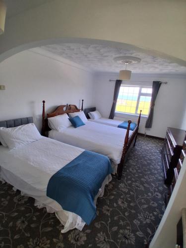 a hotel room with two beds and a window at The Shamrock B&B - Inis Oírr, Aran Islands in Inisheer