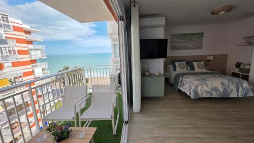 a bedroom with a balcony with a bed and the ocean at Las Brisas in Benicàssim