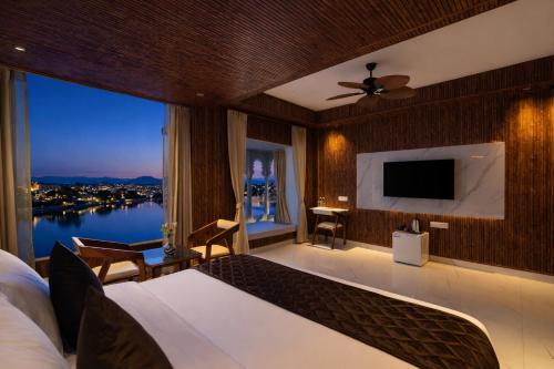 a bedroom with a large bed and a large window at Shakuntalam Sagar - Luxury Boutique Lake View Hotel, Udaipur in Udaipur