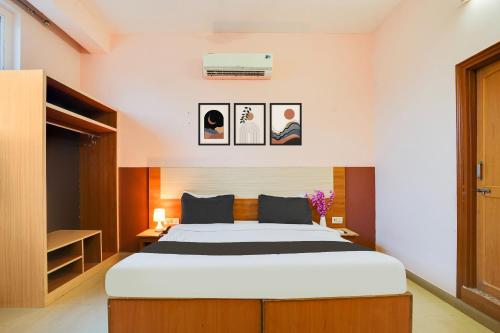 a bedroom with a large bed and pictures on the wall at Super Hotel O JLN Marg Malviya Nagar Formerly Hotel Braj Haveli in Jaipur
