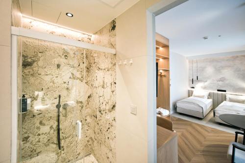 a bathroom with a shower and a bedroom at Hotel Molo Resort in Osiek