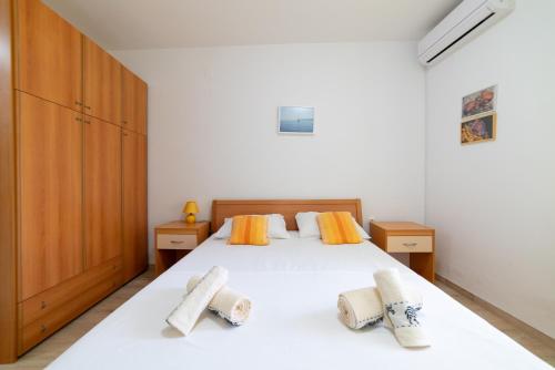 a bedroom with a white bed with two pillows at Nikola studio in Božava