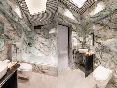 a bathroom with a sink and a toilet and a tub at Shakuntalam Sagar - Luxury Boutique Lake View Hotel, Udaipur in Udaipur
