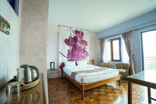 a bedroom with a bed with a purple flower on the wall at Bamboo Retreat Hotel in Gangtok