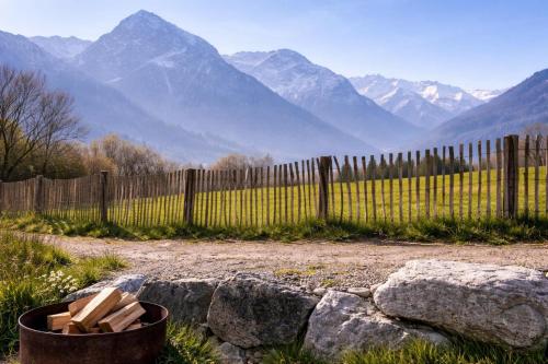 a fence in front of a field with mountains at Hotel Bergflair in Fischen
