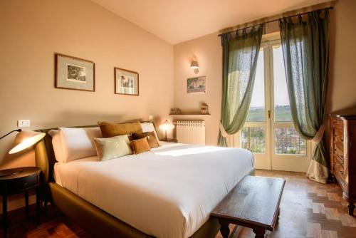 a bedroom with a large bed and a large window at B&B Casa Margot in Neive
