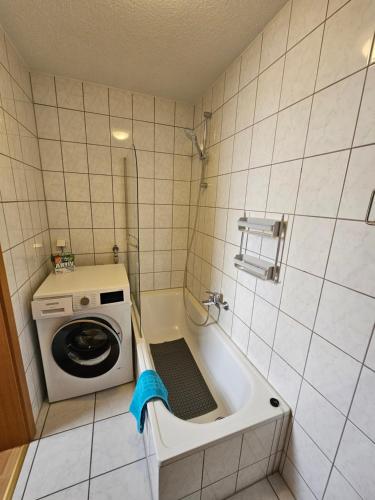 a small bathroom with a washing machine in a tub at Stadtperle in Göppingen