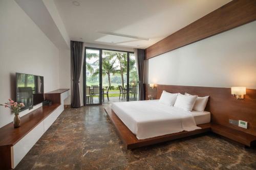 a bedroom with a bed and a large window at Villa Owner tại khu nghỉ dưỡng sinh thái Đại Lải Resort in Ngọc Quang
