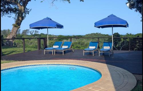 a group of chairs and umbrellas next to a pool at Ocean View Nature Lodge in St Lucia