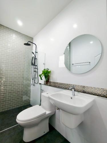 a bathroom with a toilet and a sink and a mirror at Tanner House Krabi in Ban Klang