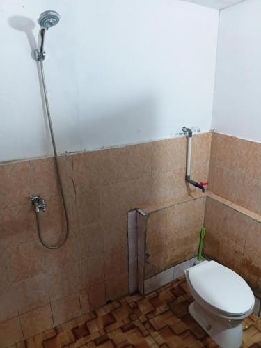a bathroom with a shower with a toilet in it at Bunaken Jhon Homestay in Manado